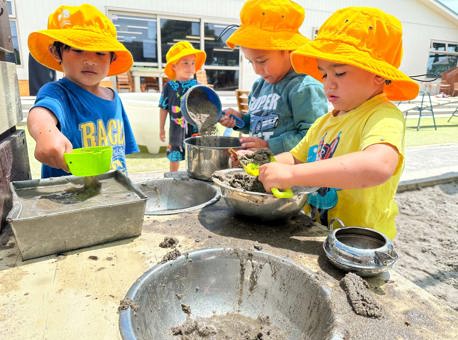 Evolve Education three Preschool boys playing in the mud kitchen at daycare
