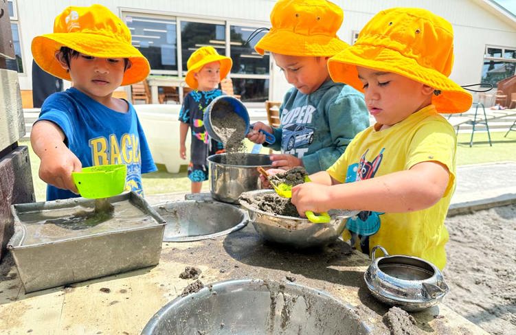 Evolve Education three Preschool boys playing in the mud kitchen at daycare