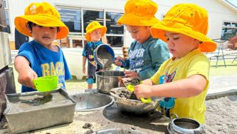 Evolve Education three Preschool boys playing in the mud kitchen at daycare