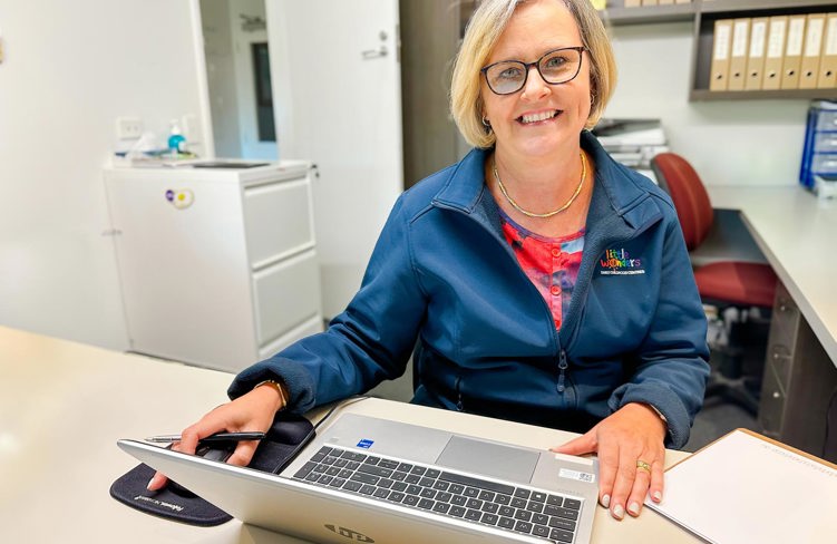Evolve Education Administrator at desk working on laptop