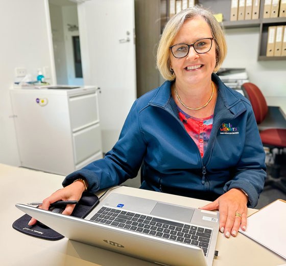 Evolve Education Administrator at desk working on laptop
