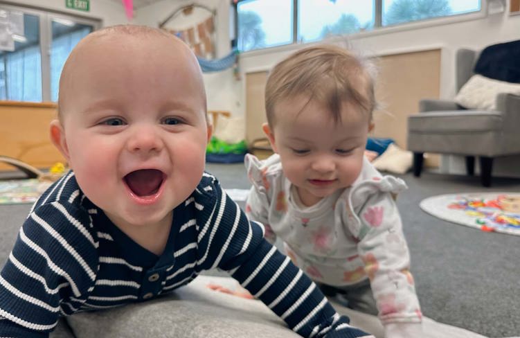 Evolve Education Two Babies smiling in the nursery space at daycare