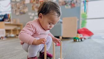 Evolve Education Toddler girl playing with abacus at daycare