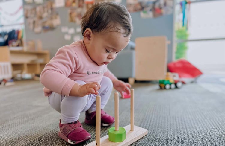 Evolve Education Toddler girl playing with abacus at daycare