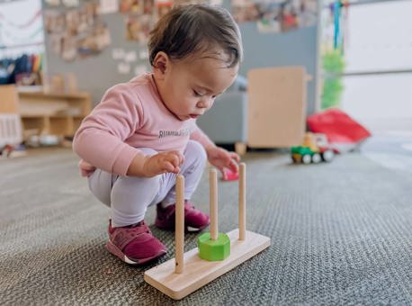 Evolve Education Toddler girl playing with abacus at daycare
