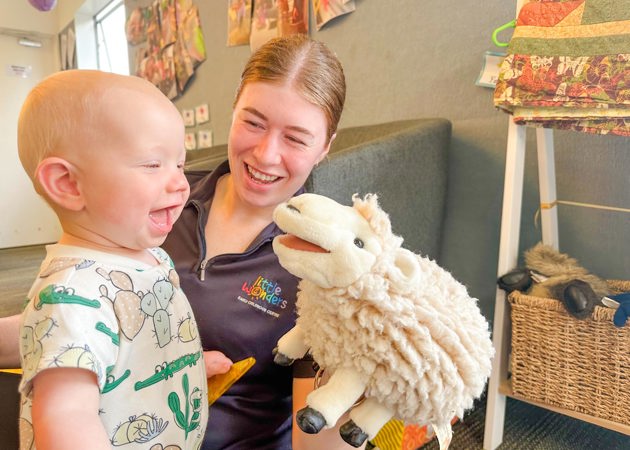 Evolve Education Teacher holding sheep toy and playing with baby