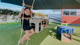 Evolve Education Preschool girl playing on ladder in playground at daycare